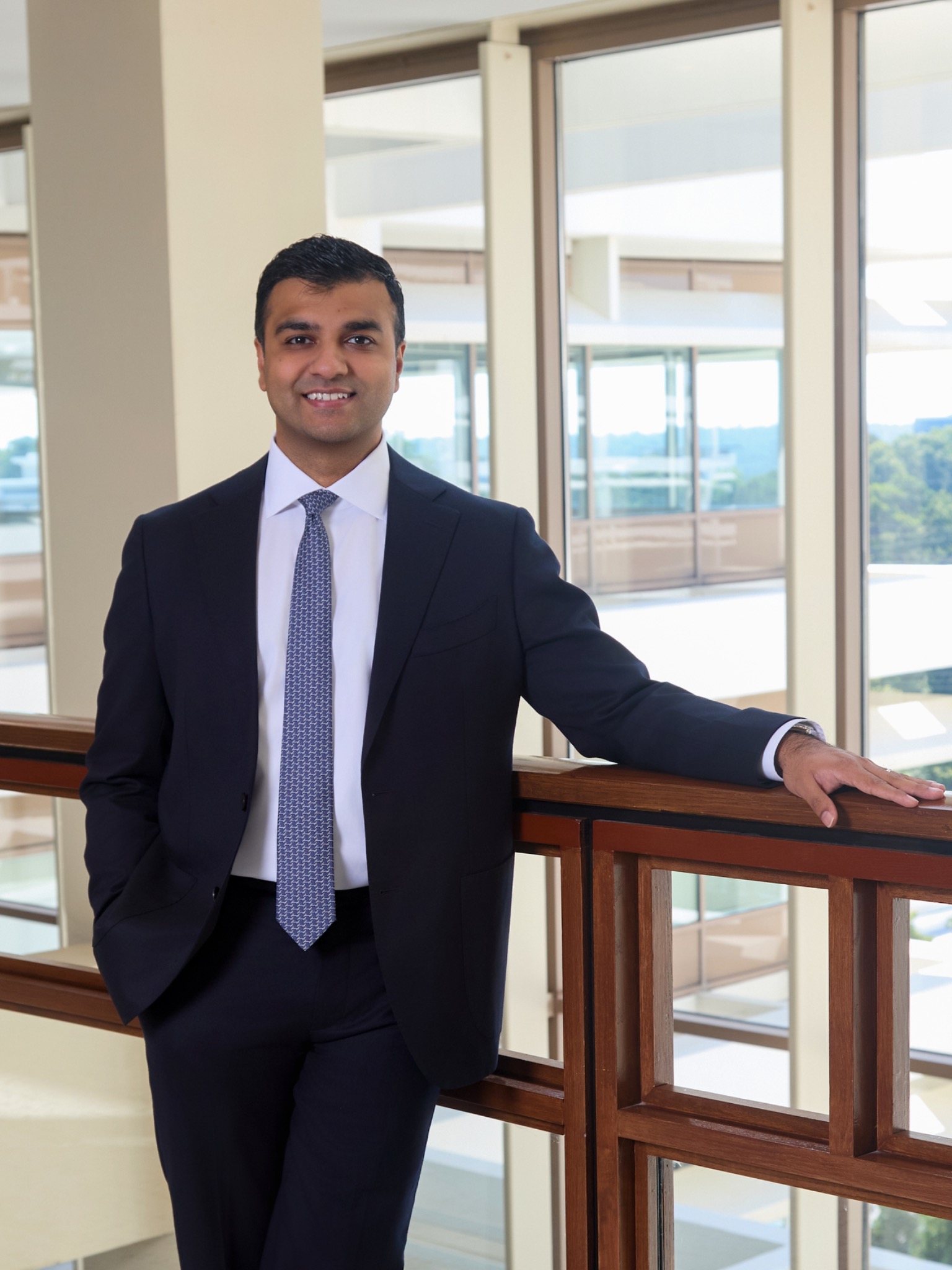 Dr. Ajit Vakharia standing beside a railing